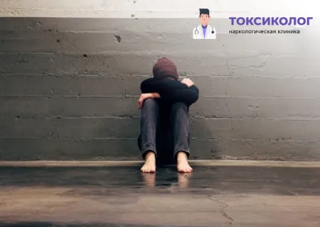 Человек в подавленном состоянии сидит на полу, комплексное лечение зависимости анонимно.