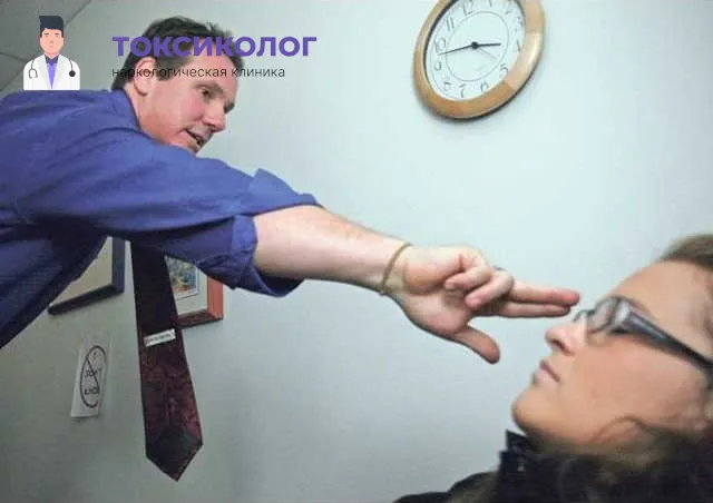 Специалист клиники Токсиколог проводит сеанс кодирования гипнозом, показывая жест пациентке.